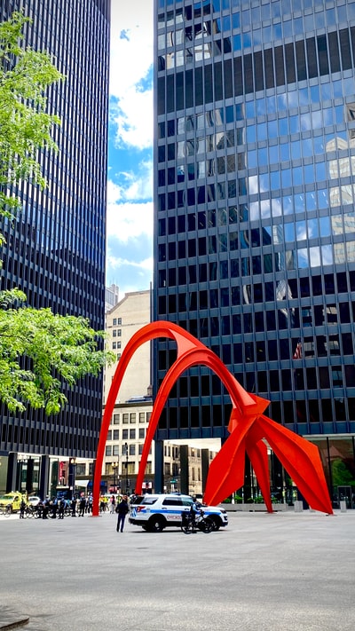 白天靠近高层建筑的红色金属框架